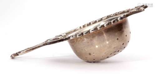 George V tea strainer of cast and applied ribbon and swag rim and integral handle to a pierced