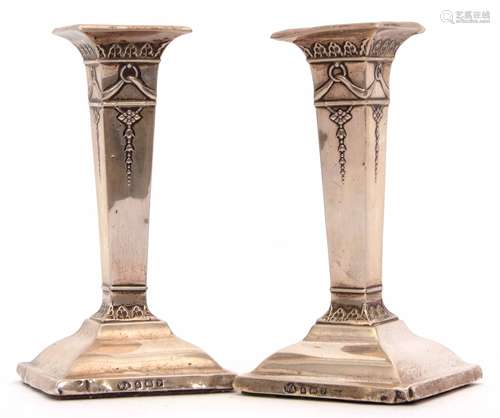 Two George V candlesticks with integral square section sconces and columns on spreading square bases