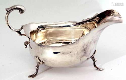 Edward VII gravy boat of typical polished form with cut card rim and leaf capped flying C-scroll