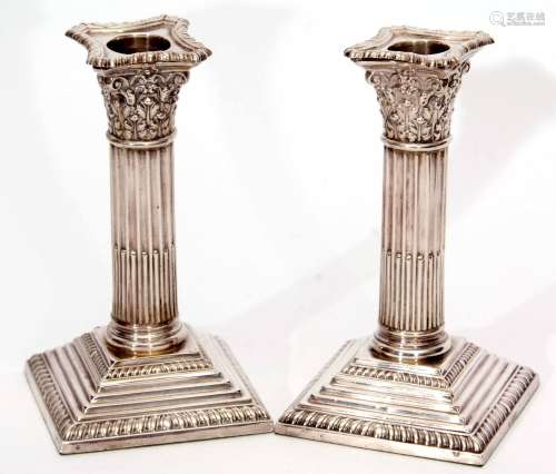 Pair of George V candlesticks modelled as Corinthian columns with detachable nozzles on stepped
