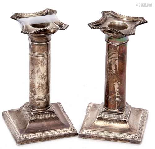 Matched pair of early 20th century candlesticks (one a/f), on plain columsn on sprading square bases
