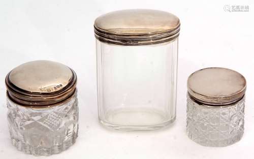 Mixed Lot: comprising three various silver lidded and clear cut glass toiletry bottles, two of