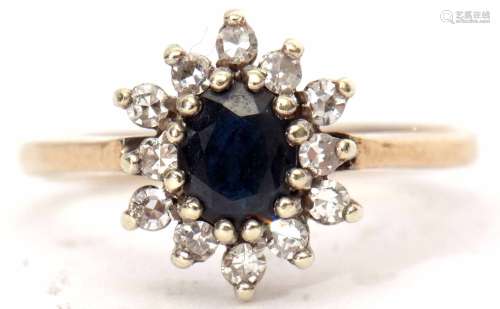 Modern 9ct gold, sapphire and diamond cluster ring, the oval faceted shaped sapphire raised within a