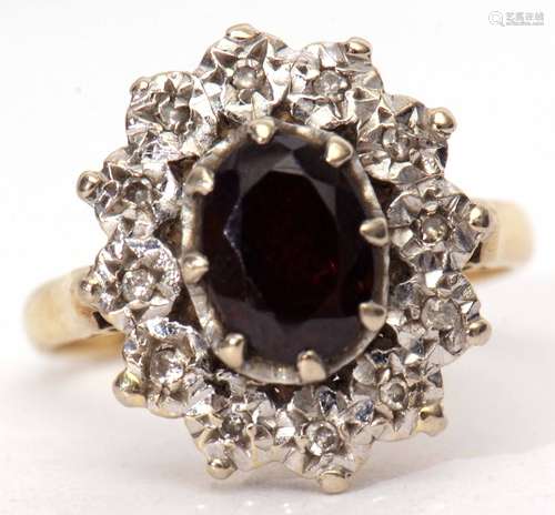 18ct gold garnet and diamond cluster ring, the oval shaped faceted garnet claw set and raised within