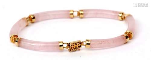 Modern yellow metal and pink jade articulated bracelet, the six cylindrical jade links each capped