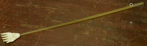 Early 20th century back-scratcher modelled as an ivory hand mounted on a long tube, 39cm long