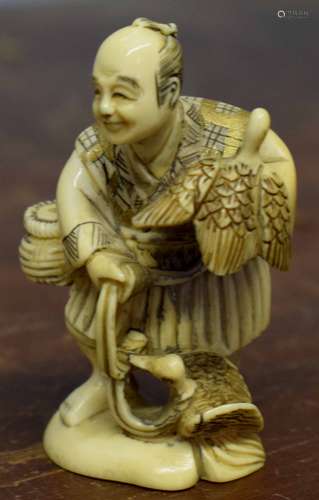 Early 20th century ivory model of a bird seller on oval base, modelled as a gentleman holding a bird