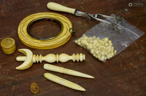 Group of ivory wares including a photo frame and collection of ivory beads and a pair of sugar tongs