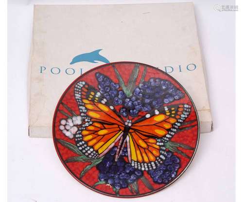 Poole Pottery charger with butterfly design on red ground, the base with factory mark, limited