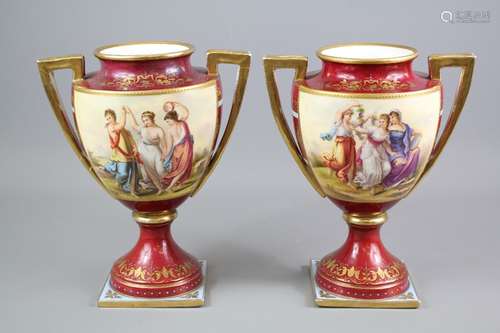 A Pair of Continental Porcelain Vases, the twin-handled vases in the Vienna-style are hand painted with decorative panels depicting 'The Three Graces' heightened with gilt beading, signed Wild, approx 23