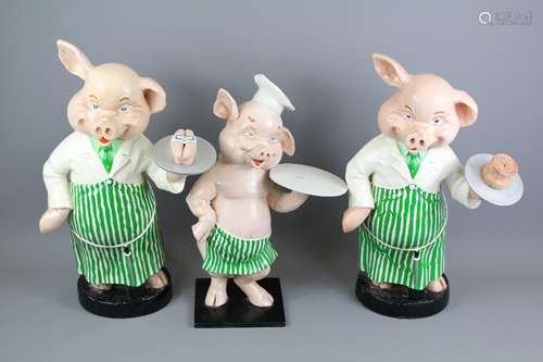 Three Vintage Composite Butchers Pigs, the pigs dressed in butcher's attire carrying trays, approx 49, 47 and 40 cms h respectively