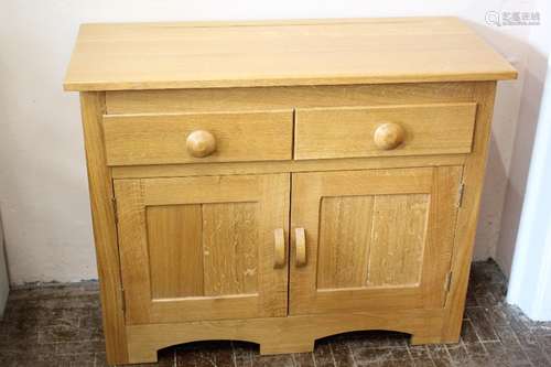 A Bespoke Light Oak Sideboard; the sideboard having two drawers, one shelf and double cupboard doors beneath, approx 102 x 43 x 81 cms