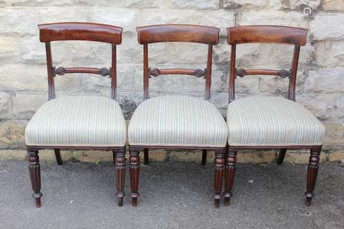 A Set of Eight Mahogany Victorian Dining Chairs, upholstered with a Regency strip, on turned legs