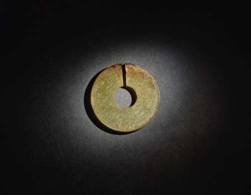 A SUPERB AND RARE ARCHAIC CELADON AND RUSSET JADE SLIT DISC (JUE) EASTERN ZHOU DYNASTY