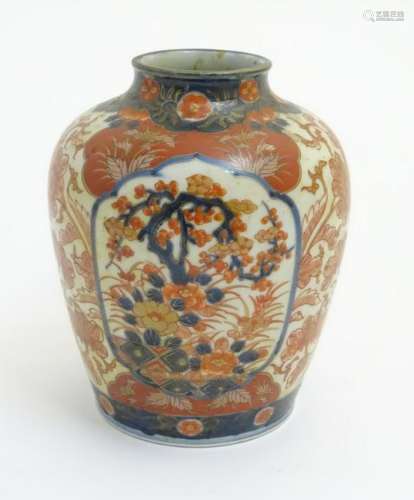 An Imari vase decorated with panels of flowering trees
