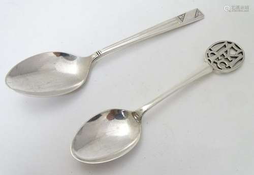 A silver teaspoon with fretwork initials to handle