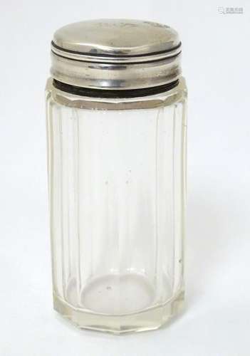 A glass jar with silver top 3 1/4'' high