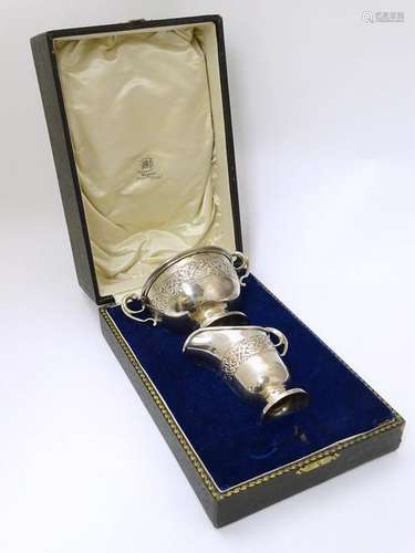 A cased silver jug and bowl with banded stylised celtic