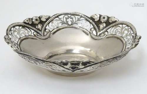 A white metal bowl with pierced and embossed