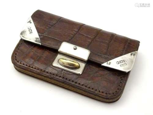 A silver mounted brown leather purse with silver