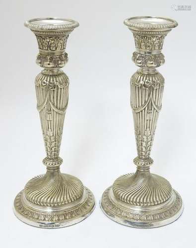 A pair of silver plate candle sticks with columns