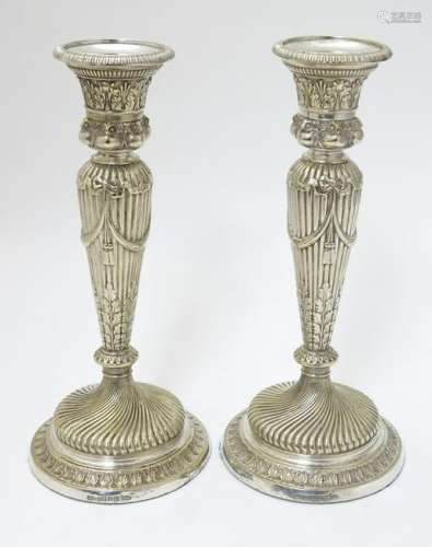 A pair of silver plate candle sticks with columns