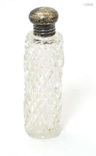 A cut glass scent / perfume bottle with silver top