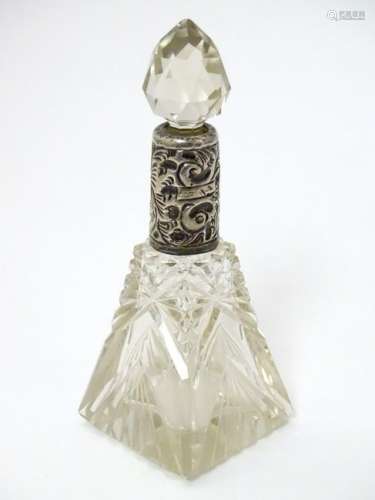 A cut glass scent / perfume bottle with embossed silver