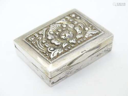 A white metal box of rectangular form with hinged lid.