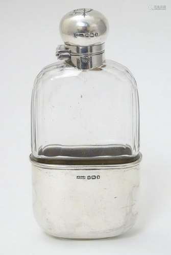 A glass hip flask  with silver mounts and beaker to