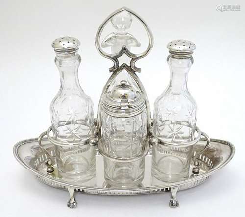 A silver plate 4-bottle cruet stand standing on four