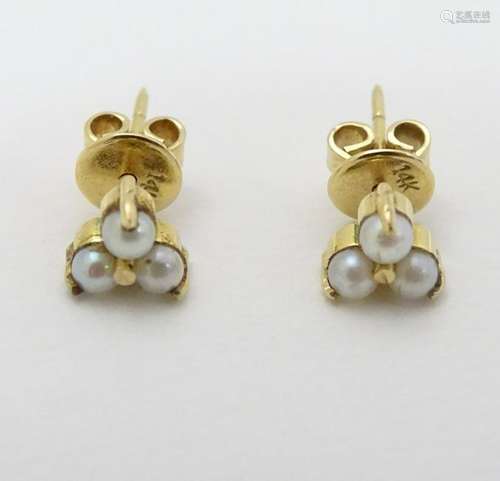 A pair of gold stud earring set with pearls