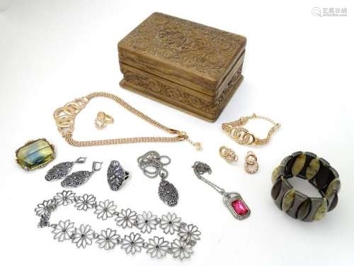 A collection of costume jewellery in a carved wooden