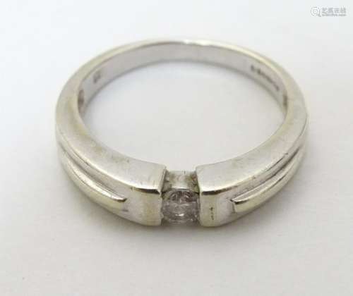 A 9ct white gold ring set with central diamond.