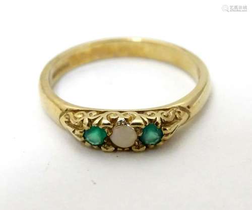 A 9ct gold ring set with white and green stones.