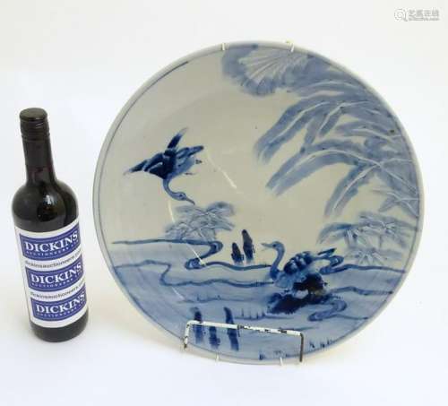 An oriental blue and white charger with hand painted