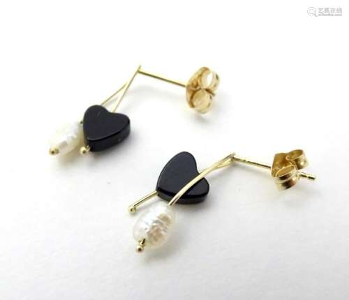 A pair of 14kt gold earrings set with onyx heart
