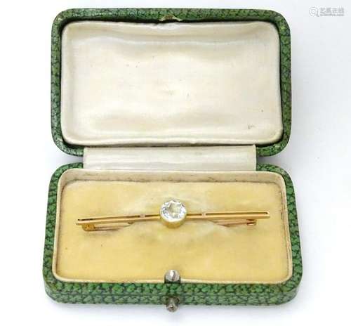 A 9ct gold bar brooch set with central aquamarine.  2''