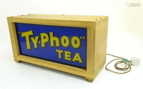 Advertising: A back lit 'Ty-phoo' tea sign,