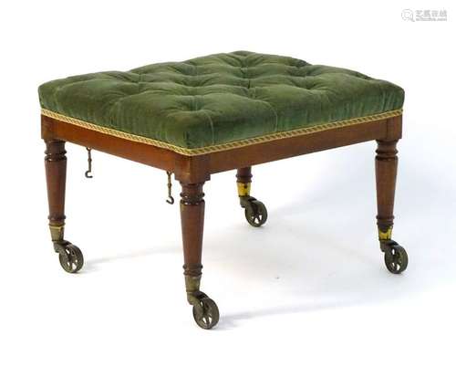 A Victorian mahogany footstool with a deep buttoned