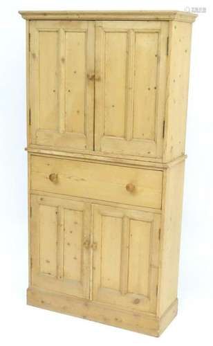 An early 20thC pine cupboard, having a moulded cornice