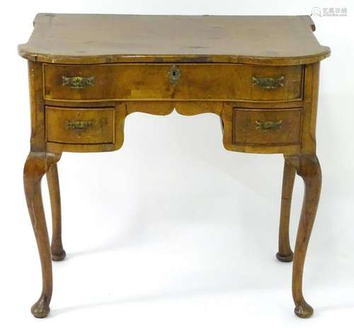 An early 19thC walnut lowboy with a castellated top