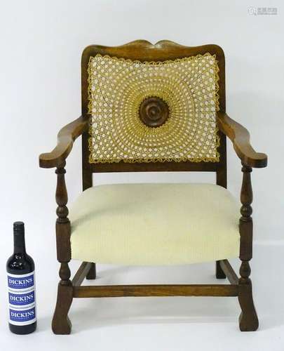 An early 20thC oak small proportion open armchair with