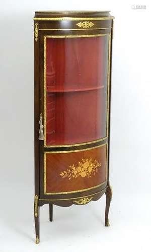 A late 20thC free standing corner cabinet, having gilt