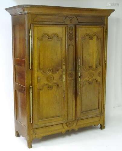 A mid 19thC walnut continental armoire with carved