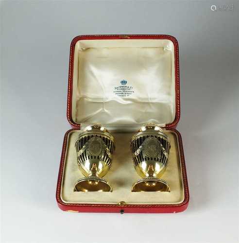 A cased pair of Adams style silver gilt pepper pots