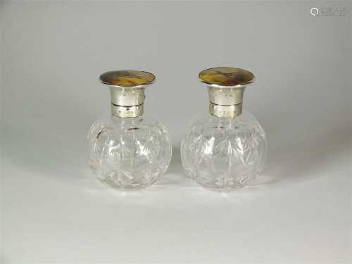 A pair of silver and Stinton enamel topped glass scent bottles