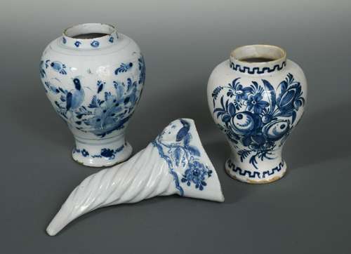 A Delft blue and white cornucopia wall pocket, the border moulded with foliage and centred with