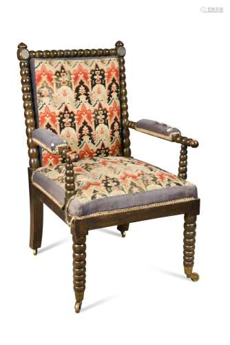 A William IV ebonised beech bobbin turned frame armchair, upholstered in a gross point needlepoint