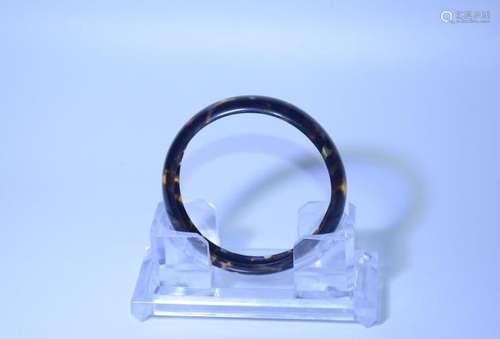 A NATURAL TORTOISESHELL JADE BANGLE.